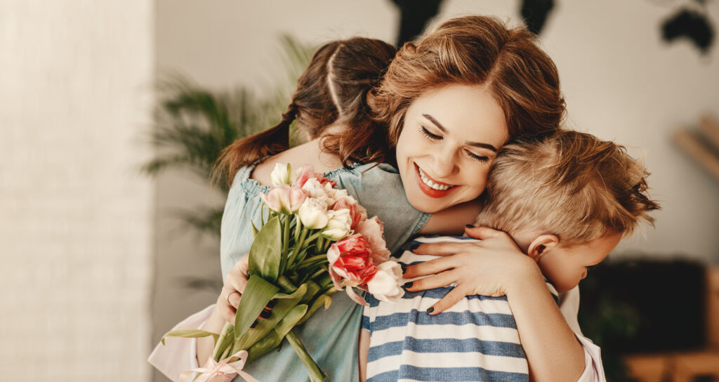 Väikesed lapsed kingivad emale emadepäevaks lilli.